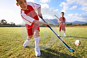 Children, ball and playing hockey on green grass for game, sports or outdoor match together. Team, kids or players