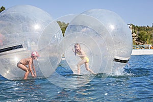 Children in a balloon floating on water.