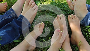 Children with bare feet sitting on green grass, grain and noise