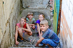 Children in the basement, three boys and a girl near the iron door are hiding on the steps from the outside world. Post-production