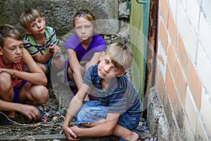 Children in the basement, three boys and a girl near the iron door are hiding on the steps from the outside world. Post-production