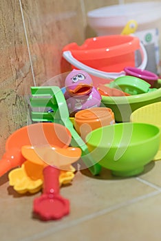 Children bath plastic toys put in the bathroom which have a pink small duck in the middle.