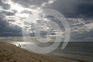 Children on beach, dramatic sky, stormy clouds