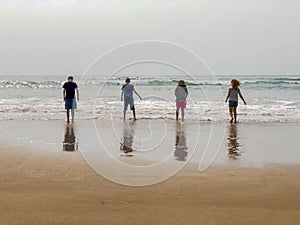 Children at beach with Reflections in Wet Sand