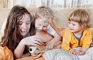 Children with beagle puppy in the bed