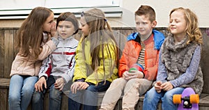 Children on a bench playing Chinese whispers photo