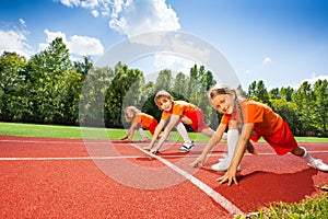 Children on bending knees in row ready to run