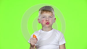 Children bites a carrot and shows a thumbs up. Green Screen. Slow motion