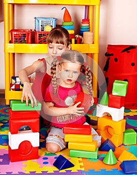 Children with block in play room.