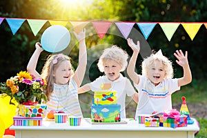 Children blow candles on birthday cake. Kids party