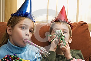 Children blowing noisemakers.
