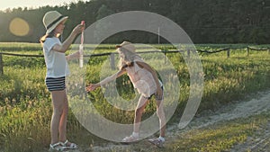 Children blowing soap bubbles, two girls playing in nature