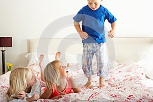 Children Bouncing On Bed