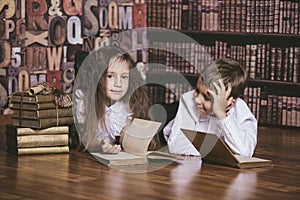 Children boy and girl children reading books in library