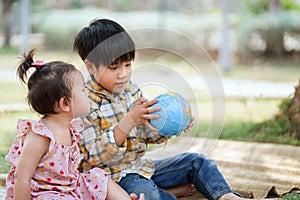 children boy and girl looking at globe for learning world map