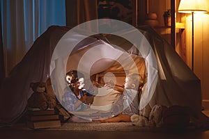 Children boy and girl playing and frighten each other in tent