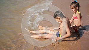 Children. boy and girl playing with sand on the beach.