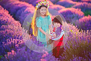 Children boy and girl in traditional Bulgarian folklore costume in lavender field during sunset