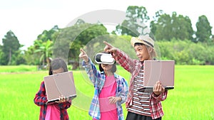 Children boy holding laptop and kids girl wearing virtual reality glasses