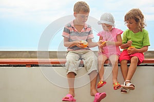 Children: boy and two girls sitting on a brach