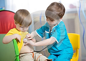 Children boys play doctor at home