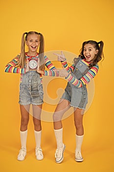 Children break concept. two cheerful girls hold alarm clock. back to school. summertime. discipline and time management