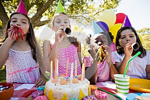 Children breathing out in a birthday trumpets during a birthday party