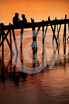 Children on bridge sunset silhouette