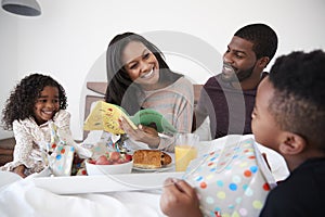 Children Bringing Mother Breakfast In Bed To Celebrate Mothers Day Or Birthday photo