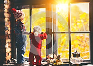 Children brother and sister admiring window for autumn