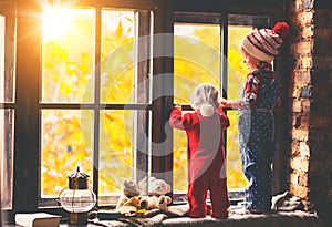 Children brother and sister admiring window for autumn