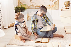 Children brother and sister, boy and girl reading a book