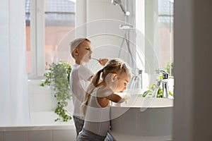 Children brother and sister wash and brush their teeth in the bathroom