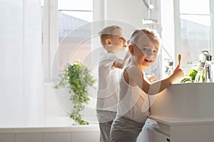 Children brother and sister wash and brush their teeth in the bathroom