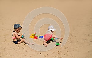 Children build sand castles and dig holes with toy shovels on the sandy beach
