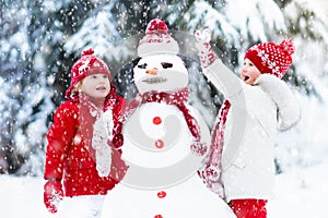 Kids building snowman. Children in snow. Winter fun. photo