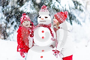 Kids building snowman. Children in snow. Winter fun.