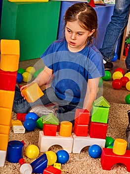 Children building blocks in kindergarten. Group kids playing toy floor .