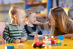 Children building blocks with a teacher in the nursery