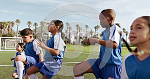 Children, cardio and sport on soccer field with leg warm up for training and school fitness. Youth, kids and workout for