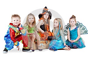 Children in carnival costumes sit on chest