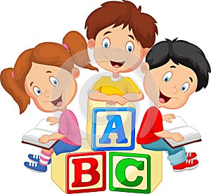 Children cartoon reading book and sitting on alphabet blocks photo