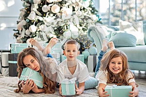 Children at Christmas tree opening presents on Xmas morning