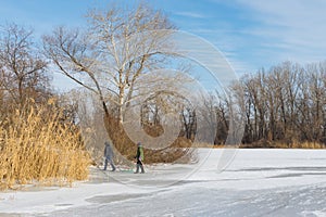 Children in the city use hilly bank of the frozen river Dnepr for to go in for sledging