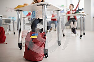 Children in classrom, detail on backpack of Ukrainian student, concept of enrolling Ukrainian kids to schools.