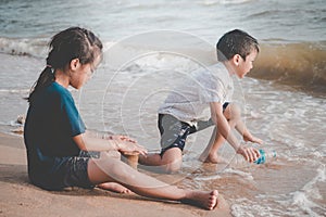 Children cleaning up garbage on the beach for enviromental clean up concept