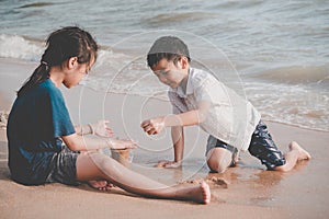 Children cleaning up garbage on the beach for enviromental clean up concept