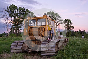 Children climb on the tractor CHTZ-URALTRAK T-130. A Soviet agricultural and industrial tracked tractor