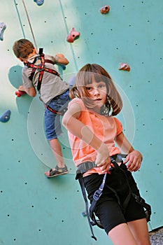 Children with climbing equipment against the training wall