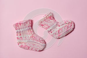 Children clothes concept on a white background. Pink knitted booties. Isolate